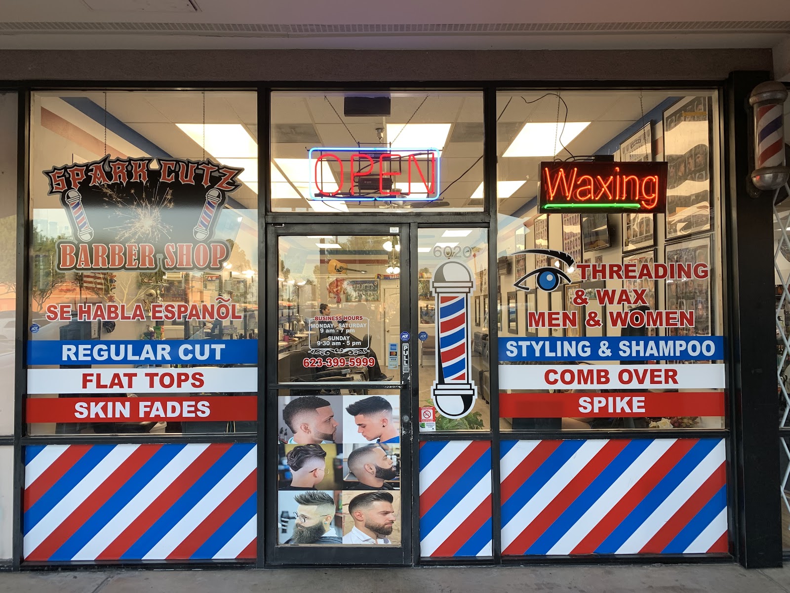 Spark Cutz storefront at night: striped windows, neon OPEN sign, neon Waxing sign, and hand-painted service lettering