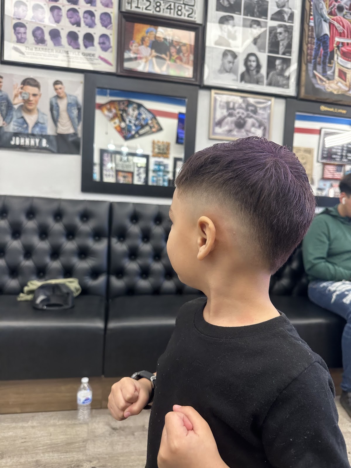 A kid showing off a fresh mid fade in front of the waiting bench